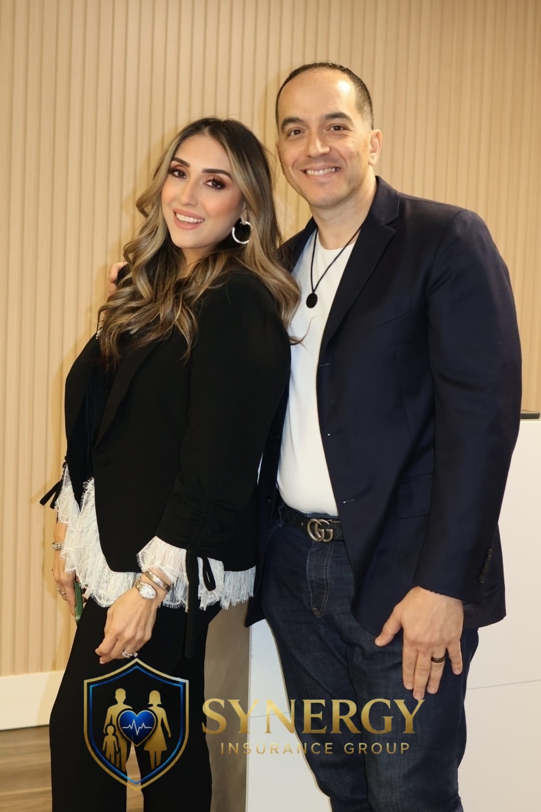 Dos integrantes del equipo de Synergy de pie juntas en la oficina.